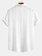 Kahvinruskean jacquard-paidan vinoneliökuvion lähikuva.