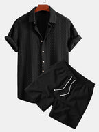 Musta jacquard-nappipaita ja kreppipintaiset shortsit mallin päällä edestä.