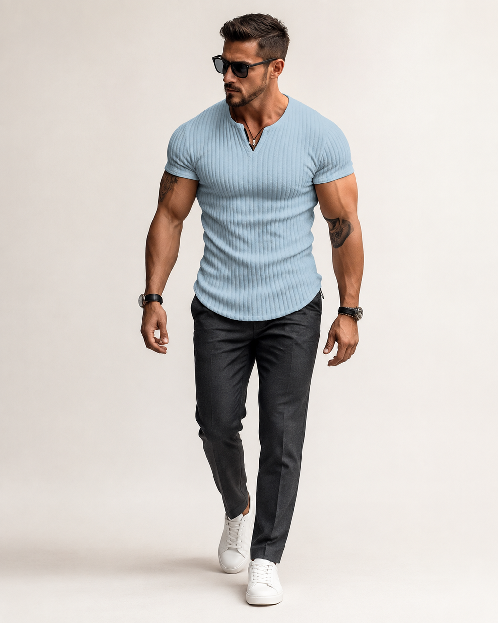 Aikuinen miesmalli vaaleansinisessä ribbineulotussa slim fit Henley-paidassa luonnonvalkoisessa studiossa