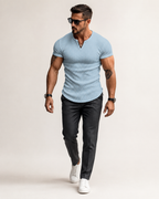 Aikuinen miesmalli vaaleansinisessä ribbineulotussa slim fit Henley-paidassa luonnonvalkoisessa studiossa