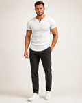 Aikuinen miesmalli valkoisessa ribbineulotussa slim fit Henley-paidassa luonnonvalkoisessa studiossa