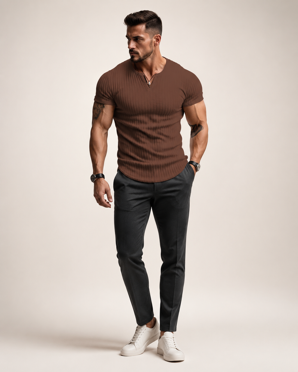 Aikuinen miesmalli ruskeassa ribbineulotussa slim fit Henley-paidassa luonnonvalkoisessa studiossa
