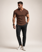 Aikuinen miesmalli ruskeassa ribbineulotussa slim fit Henley-paidassa luonnonvalkoisessa studiossa