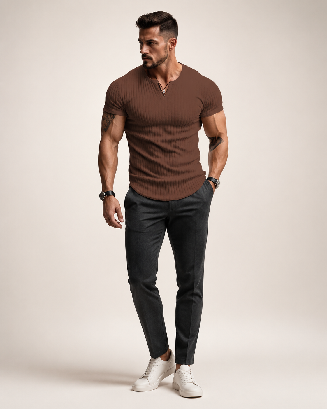Aikuinen miesmalli ruskeassa ribbineulotussa slim fit Henley-paidassa luonnonvalkoisessa studiossa