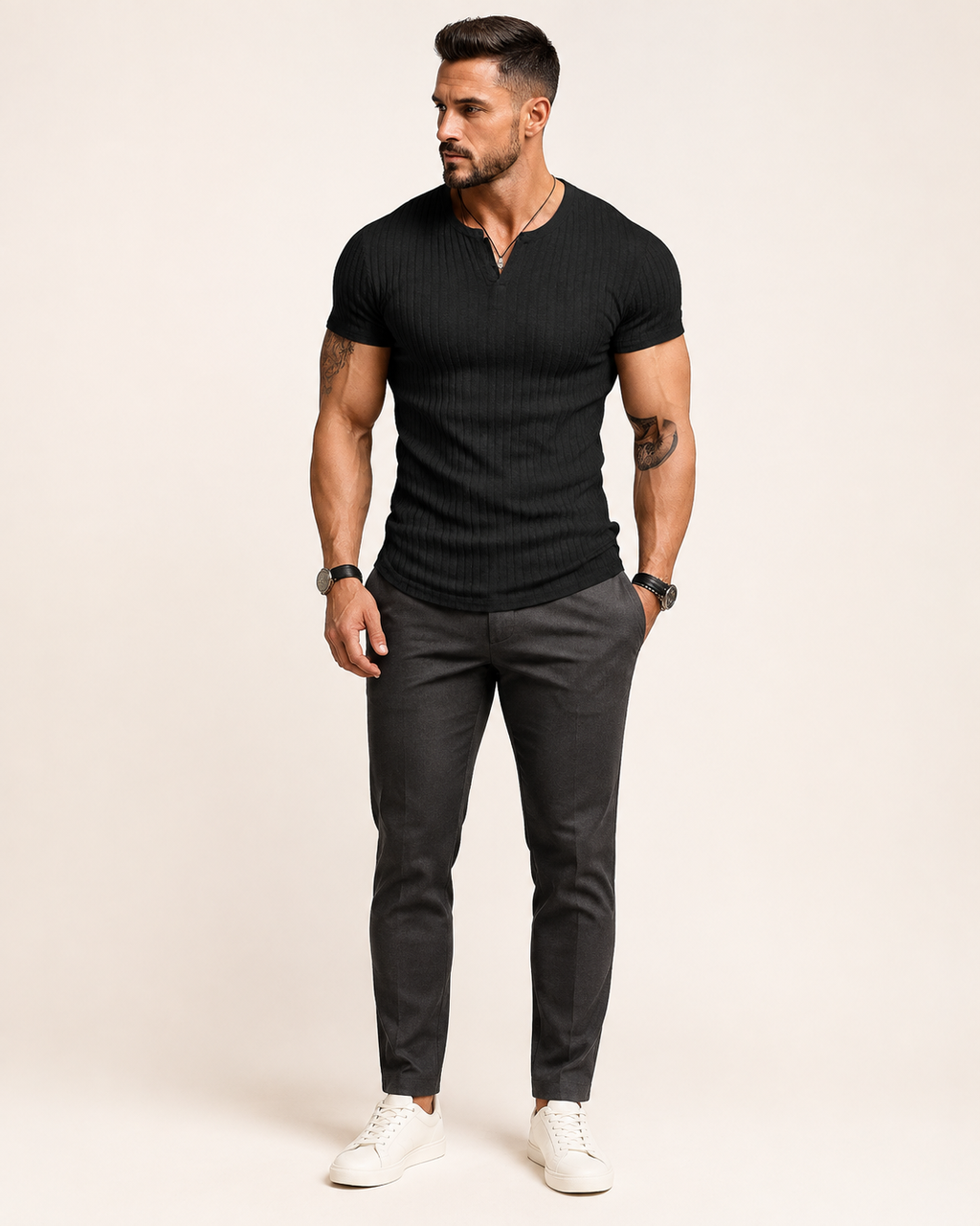 Aikuinen miesmalli mustassa ribbineulotussa slim fit Henley-paidassa luonnonvalkoisessa studiossa