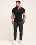 Aikuinen miesmalli mustassa ribbineulotussa slim fit Henley-paidassa luonnonvalkoisessa studiossa