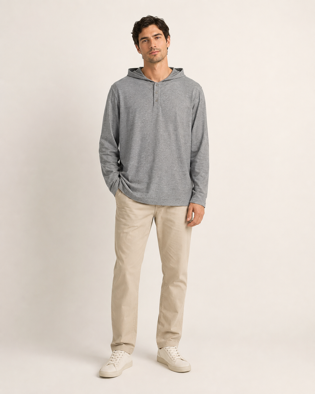 Harmaa väljä huppupusero aikuisen miesmallin yllä lämpimän valkoisessa studiossa